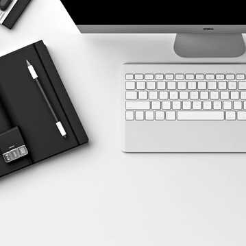 Monitor, Tastatur und Notizbuch mit Stift steht für Verwaltung und Datenpflege