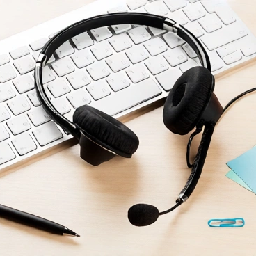 Headset auf Schreibtisch  – Symbol für Kundenservice und Kommunikation.
