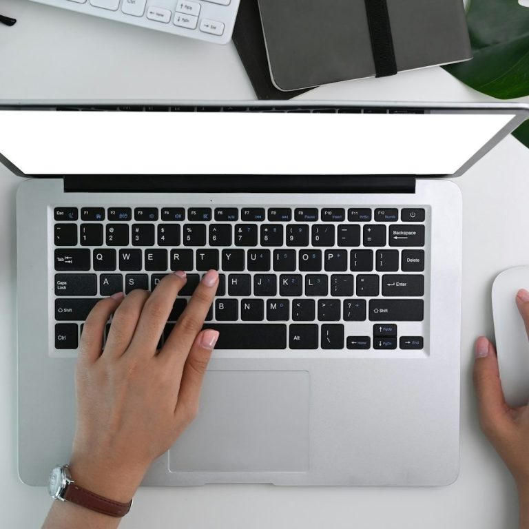 Laptop mit tippender Hand – steht für Schreibservice und Transkription als virtuelle Assistenz